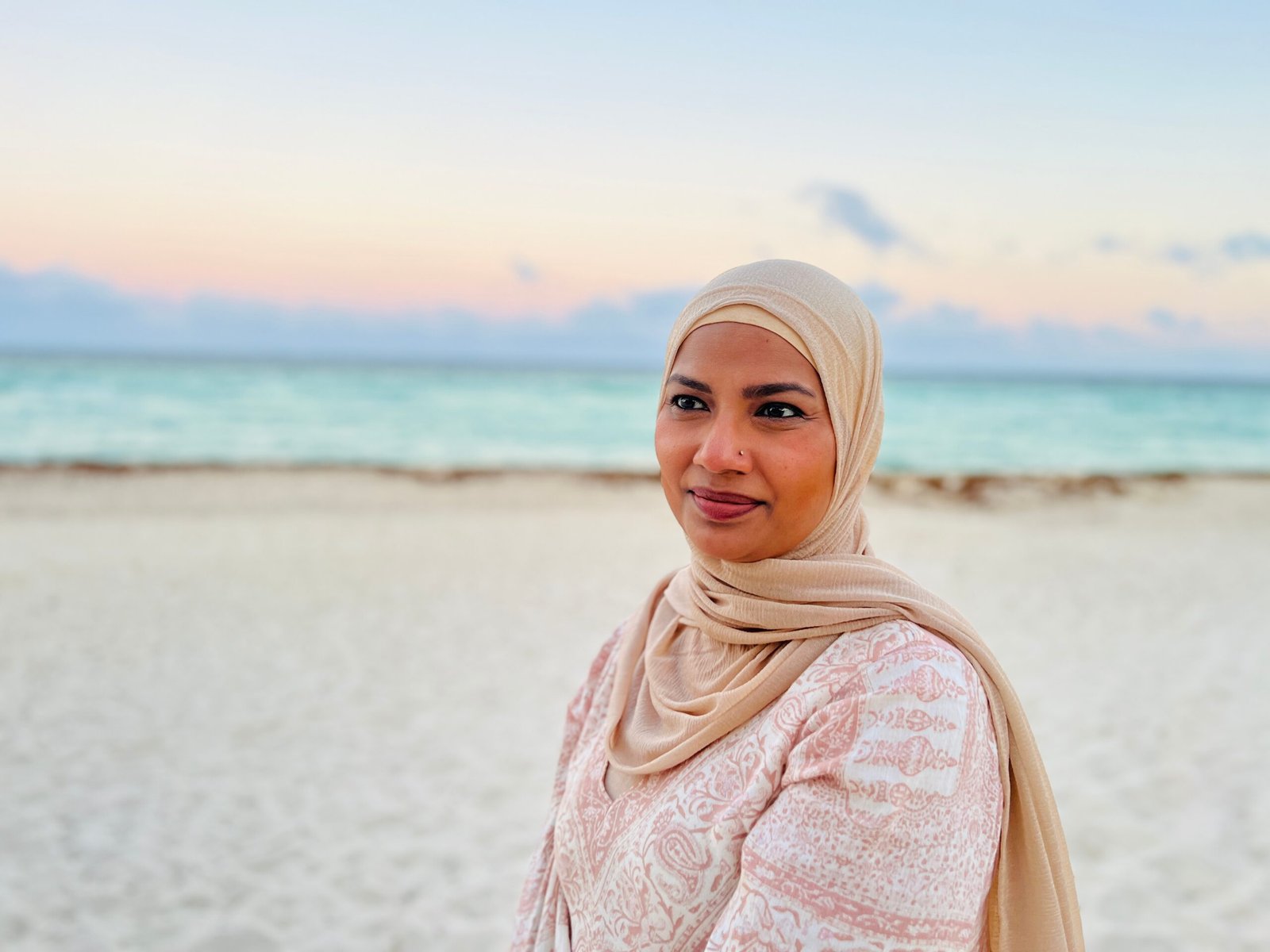 Dr. Farzana Badrun, MD, MPH, smiling on a beach, founder of New Essence Health in Atlanta